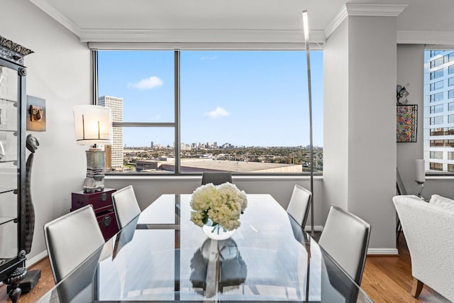 dining space with hardwood / wood-style floors and crown molding