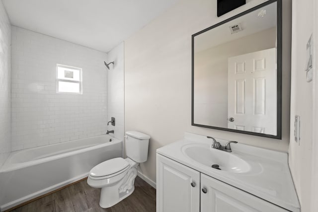 full bathroom with vanity, hardwood / wood-style flooring, toilet, and tiled shower / bath combo