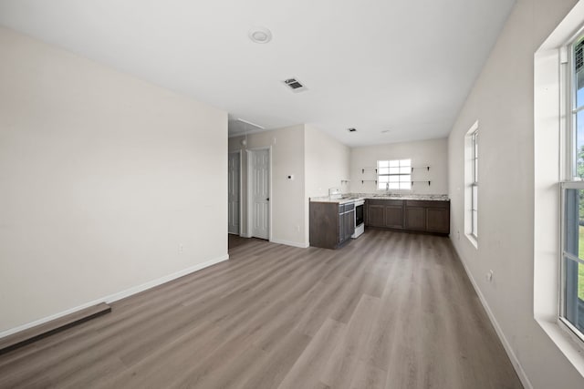 unfurnished living room with sink and light hardwood / wood-style floors