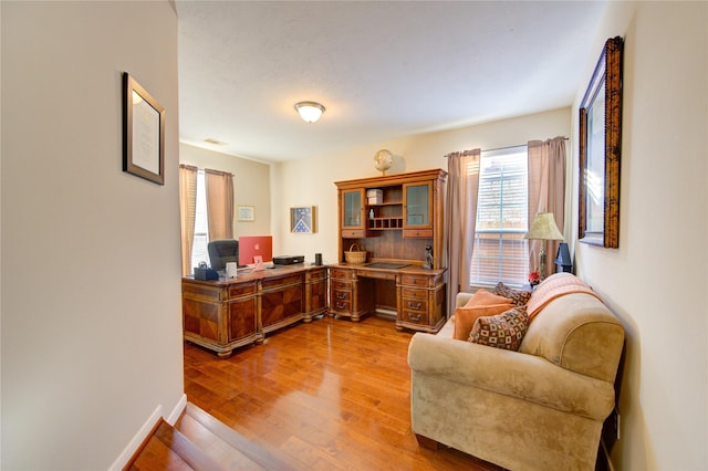 office featuring wood finished floors, visible vents, and baseboards