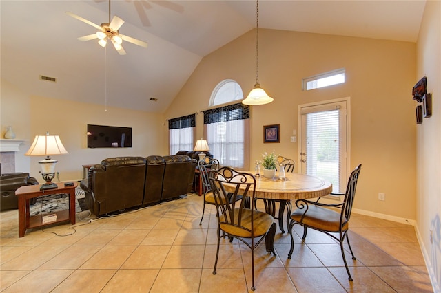 dining area with light tile patterned floors, visible vents, baseboards, a ceiling fan, and high vaulted ceiling