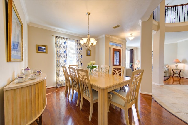 dining space with ornamental molding, a wealth of natural light, dark wood-type flooring, and visible vents