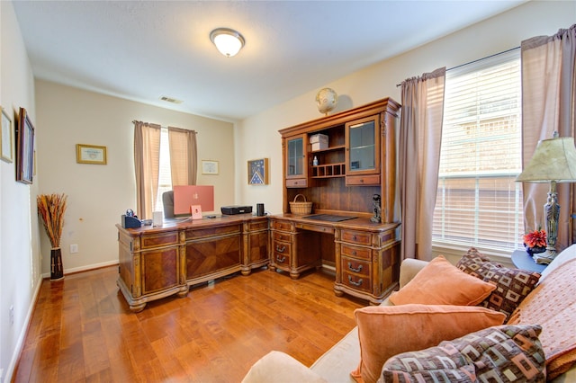 office area with visible vents, plenty of natural light, and wood finished floors