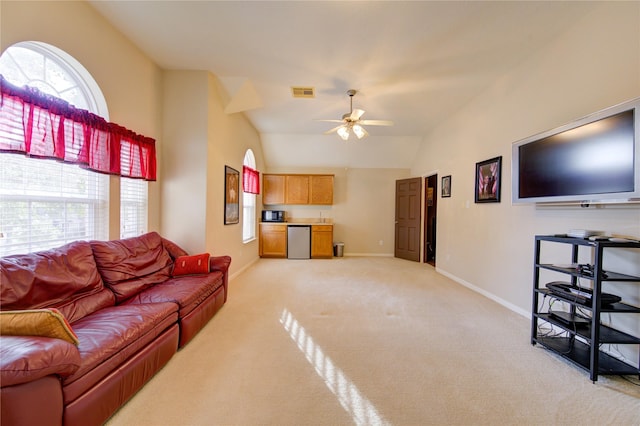 living area featuring visible vents, baseboards, a ceiling fan, light colored carpet, and vaulted ceiling