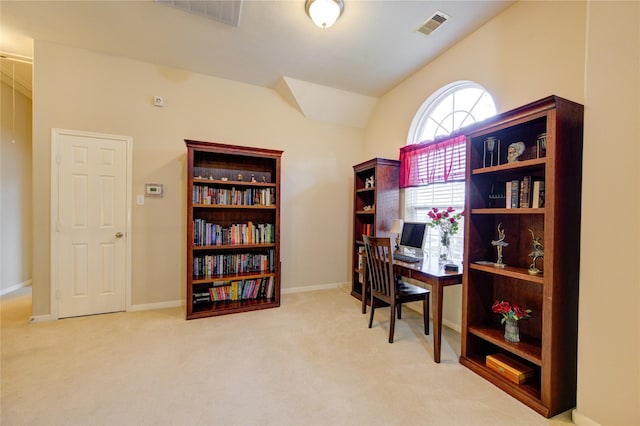 office featuring baseboards, visible vents, vaulted ceiling, and light colored carpet