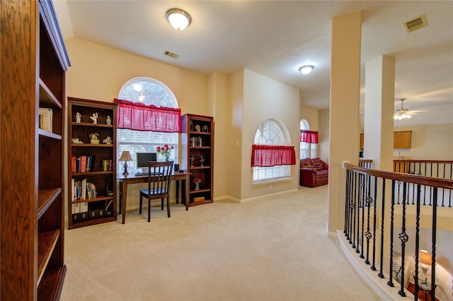 office area with light carpet, ceiling fan, visible vents, and baseboards