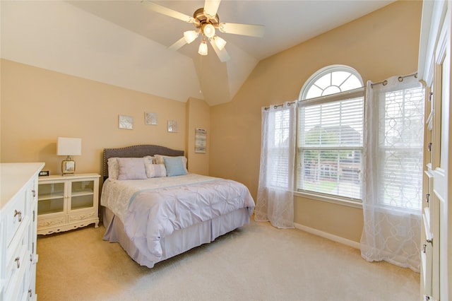 bedroom with ceiling fan, baseboards, vaulted ceiling, and light colored carpet