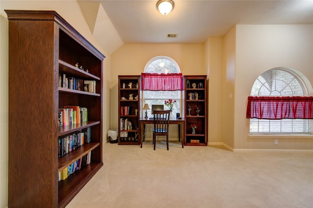 carpeted home office featuring baseboards, visible vents, and vaulted ceiling