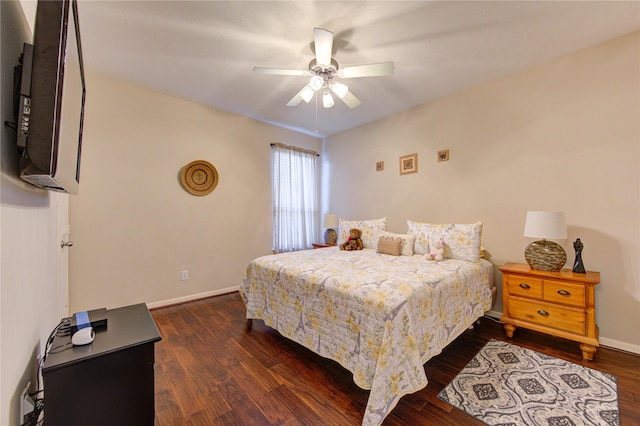 bedroom with a ceiling fan, baseboards, and dark wood-type flooring