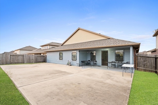 back of property featuring a yard and a patio area