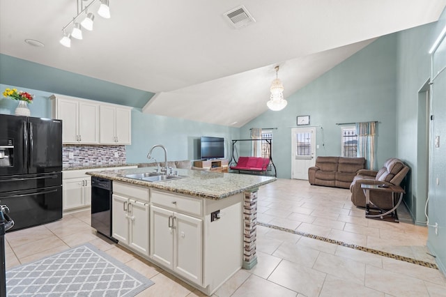 kitchen featuring sink, hanging light fixtures, black appliances, white cabinets, and a center island with sink