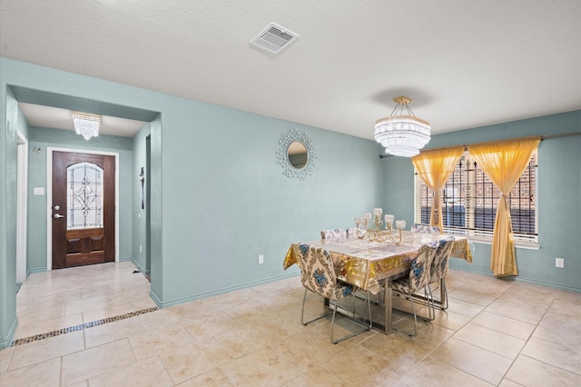 tiled dining area with an inviting chandelier