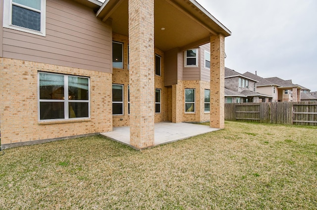 back of property featuring a patio area and a lawn