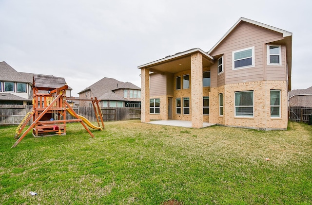 back of house featuring a yard, a patio, and a playground