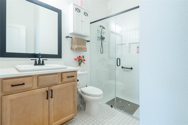 bathroom featuring vanity, an enclosed shower, and toilet