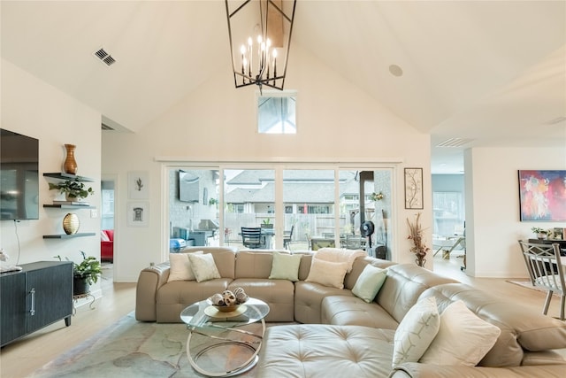 living room featuring high vaulted ceiling and light hardwood / wood-style floors