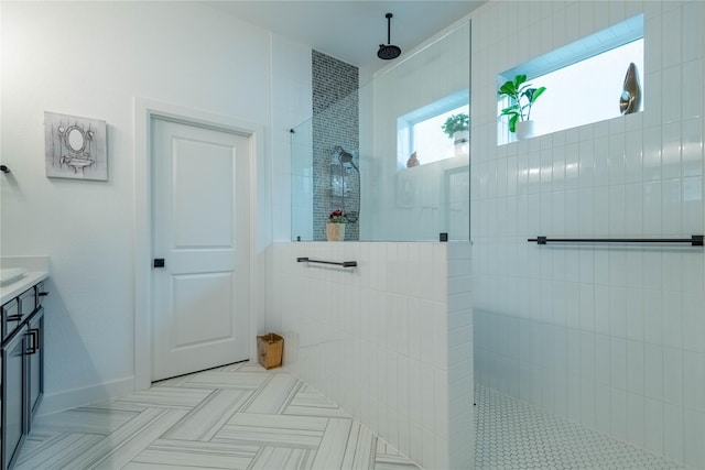 bathroom with vanity, a tile shower, and tile patterned floors