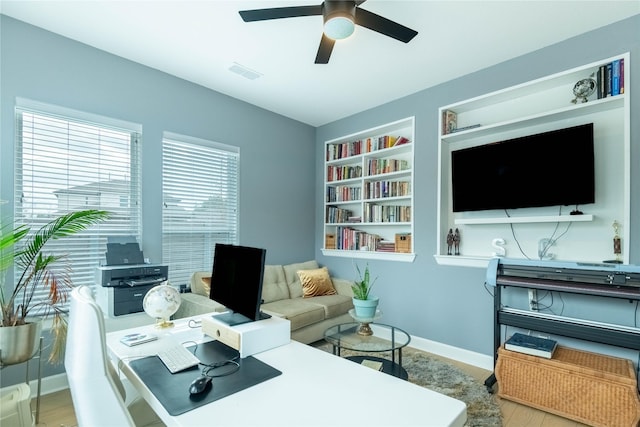 office area featuring ceiling fan, light hardwood / wood-style flooring, and built in features