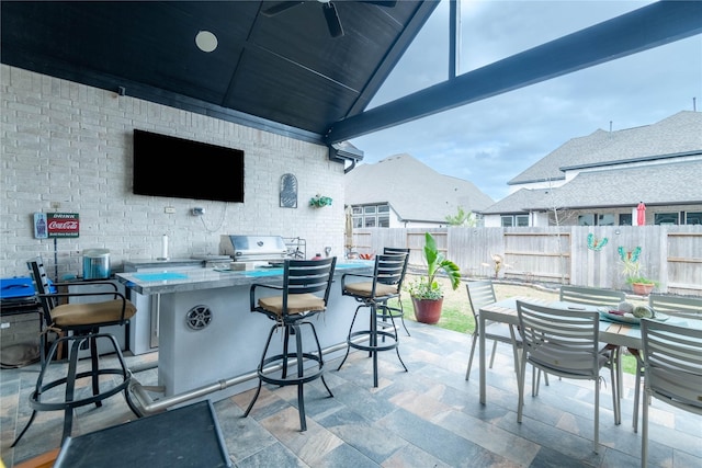 view of patio with an outdoor bar, an outdoor kitchen, ceiling fan, and area for grilling