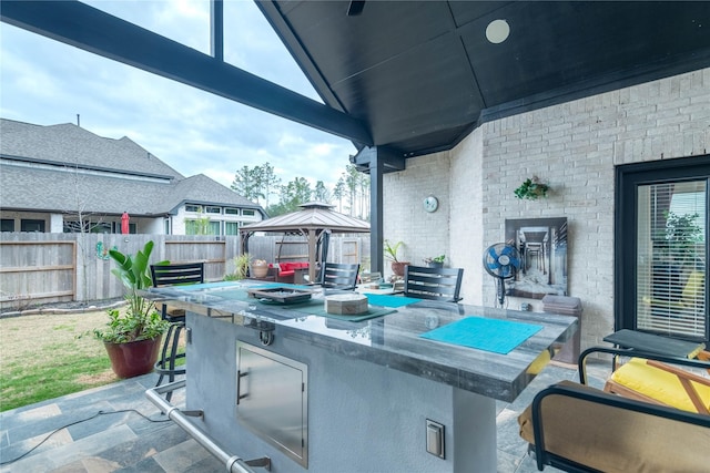 view of patio featuring area for grilling, a bar, and a gazebo