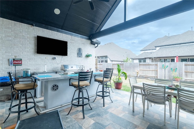 view of patio / terrace featuring ceiling fan, area for grilling, exterior kitchen, and exterior bar