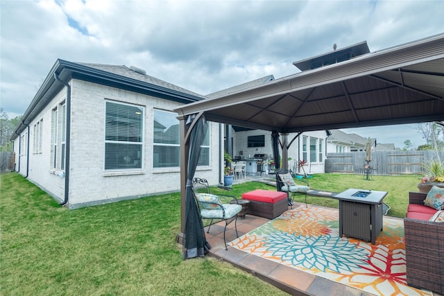 rear view of house featuring a yard, a patio area, a gazebo, and an outdoor living space with a fire pit