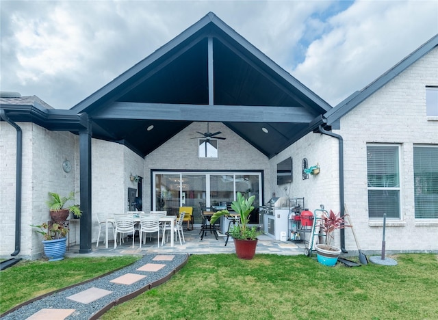 rear view of property with a patio, a yard, and ceiling fan