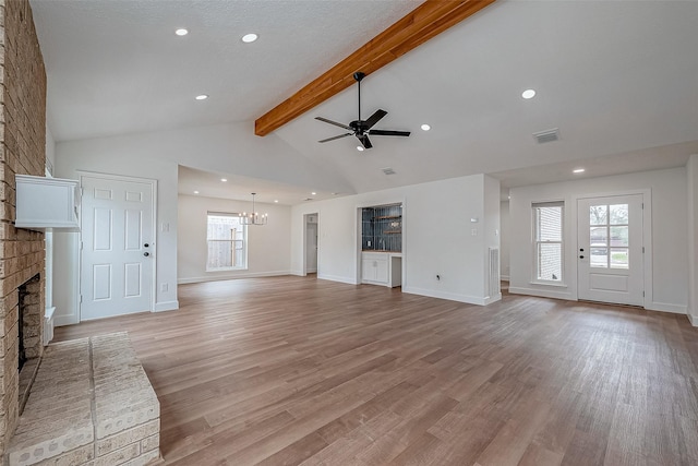 unfurnished living room featuring a brick fireplace, ceiling fan with notable chandelier, light hardwood / wood-style floors, and beamed ceiling