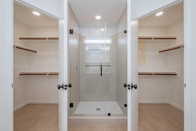 bathroom featuring a textured ceiling and a shower with shower door