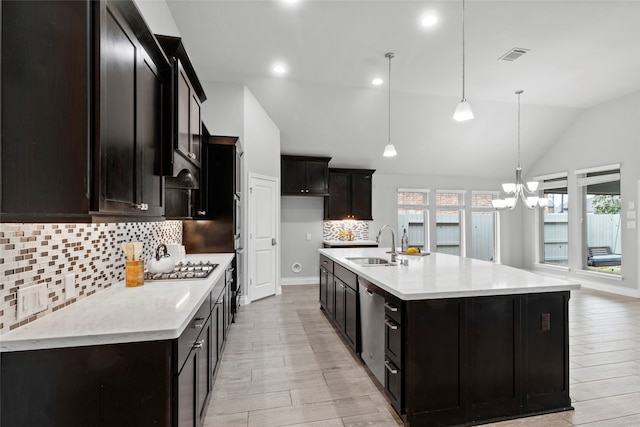 kitchen featuring lofted ceiling, a chandelier, a sink, visible vents, and light wood finished floors