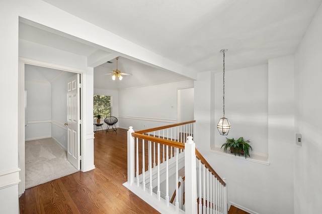 hall with baseboards, vaulted ceiling with beams, wood finished floors, and an upstairs landing