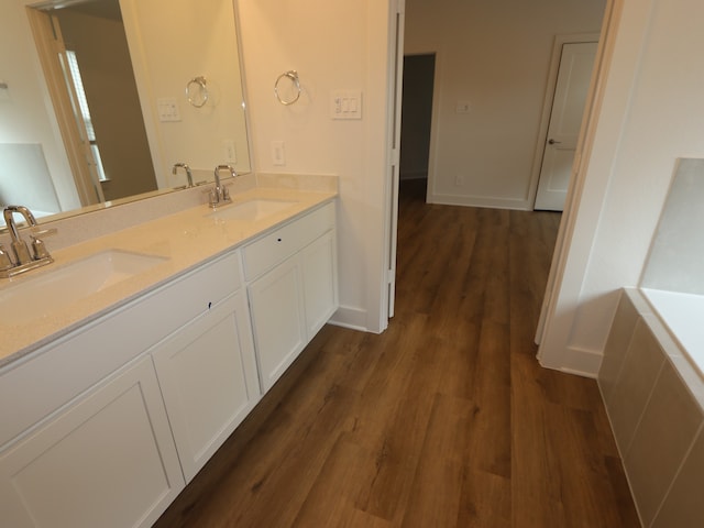 9811 Robard Ridge Ct, Montgomery, TX 77316 - bathroom featuring wood finished floors, double vanity, a bathtub, and baseboards