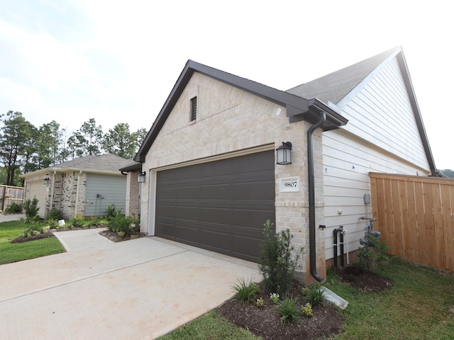 9811 Robard Ridge Ct, Montgomery, TX 77316 - view of home's exterior with concrete driveway, a garage, and stone siding