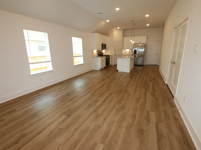 9811 Robard Ridge Ct, Montgomery, TX 77316 - unfurnished living room with light wood-type flooring, recessed lighting, vaulted ceiling, and baseboards