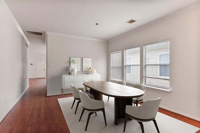 dining room featuring ornamental molding and dark hardwood / wood-style flooring