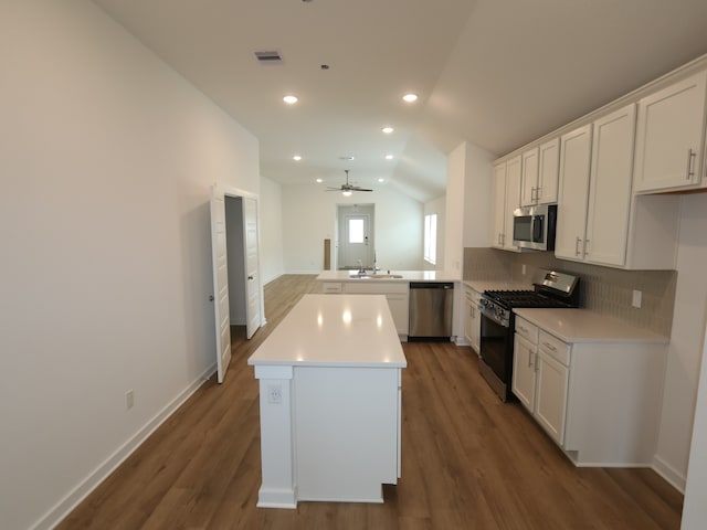 26235 Astral Way, La Marque, TX 77568 - kitchen with stainless steel appliances, a peninsula, dark wood-style flooring, lofted ceiling, and backsplash