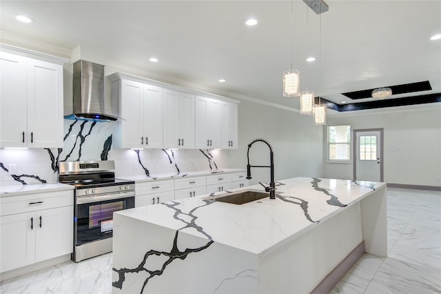 kitchen featuring decorative light fixtures, sink, a kitchen island with sink, electric range, and wall chimney exhaust hood