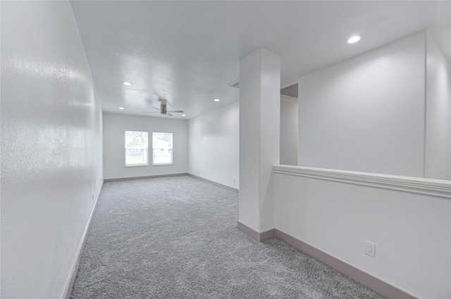 empty room featuring ceiling fan and light colored carpet