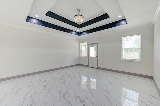 spare room featuring ornamental molding and a raised ceiling