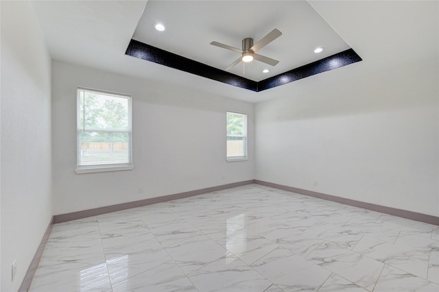 unfurnished room featuring a tray ceiling and ceiling fan