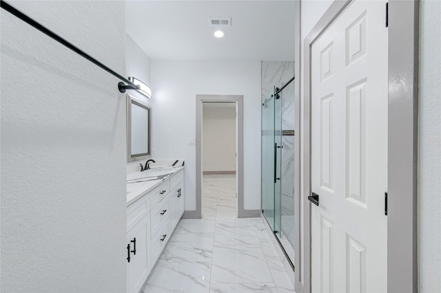 bathroom with vanity and a shower with door