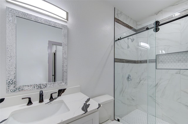 bathroom featuring vanity, a shower with shower door, and toilet