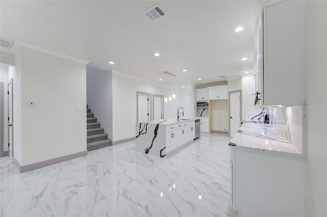 kitchen featuring white cabinetry, crown molding, a center island, hanging light fixtures, and stainless steel appliances