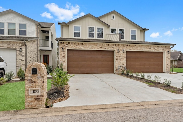 multi unit property featuring concrete driveway, brick siding, board and batten siding, and an attached garage