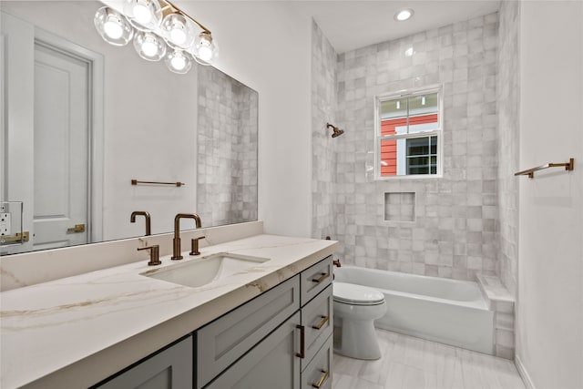 full bathroom with vanity, tiled shower / bath, and toilet