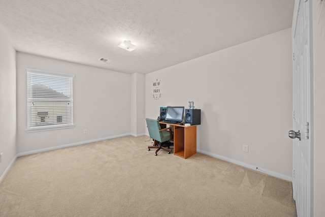 carpeted office featuring a textured ceiling