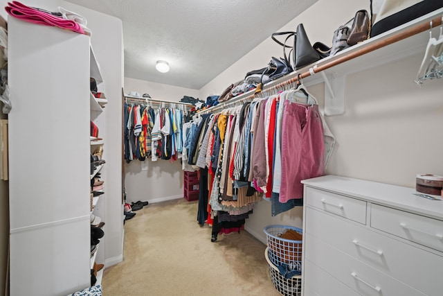 spacious closet featuring light colored carpet