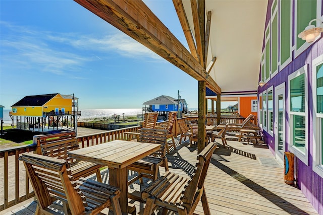 wooden deck with a water view and a beach view