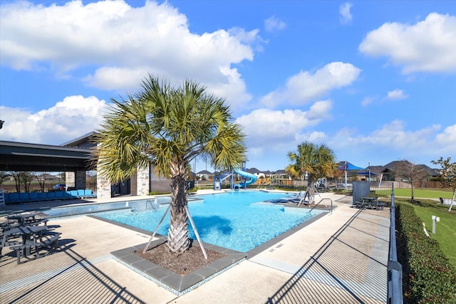 view of swimming pool with a patio area and a water slide