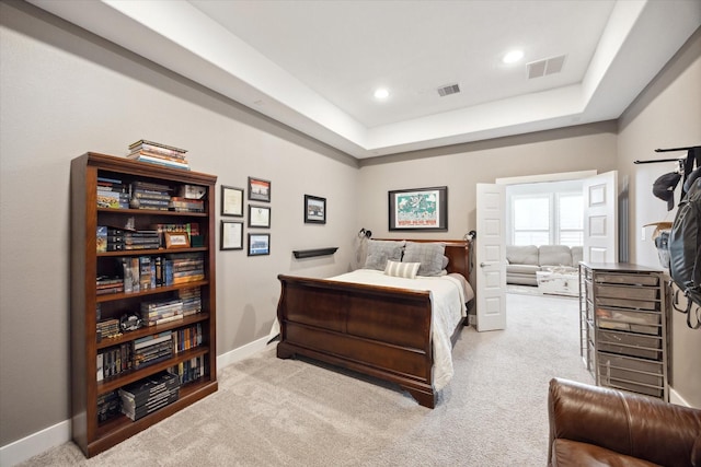 carpeted bedroom featuring a raised ceiling